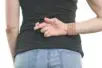 A woman stands with her fingers crossed behind her back