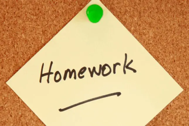 A yellow post-it with the word "homework" written on it is pinned to a cork board