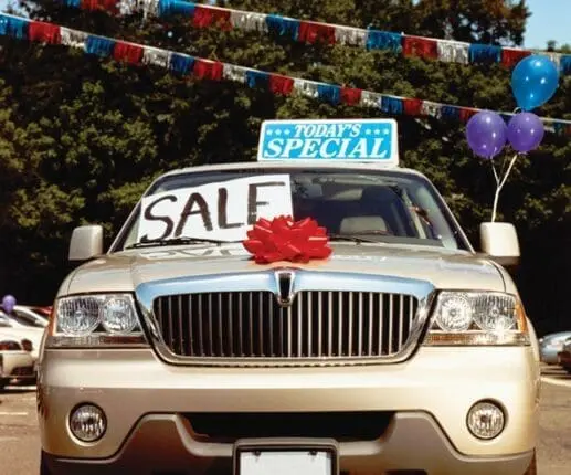 A car with a "for sale" sign on the windshield