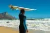 A surfer with a board on his head standing on the beach