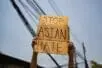 Hands holding a sign that reads "Stop Asian Hate"
