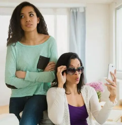 A woman ignores another woman by using her phone