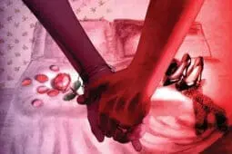 A couple holds hands in front of a bed