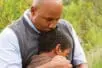 A father holds his son to his chest