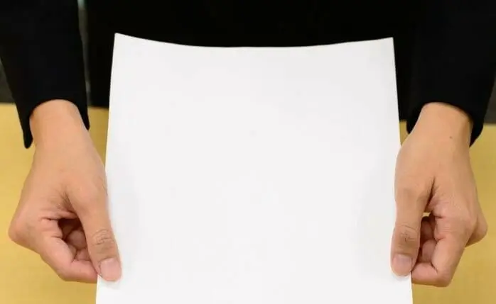 Hands holding a blank piece of paper