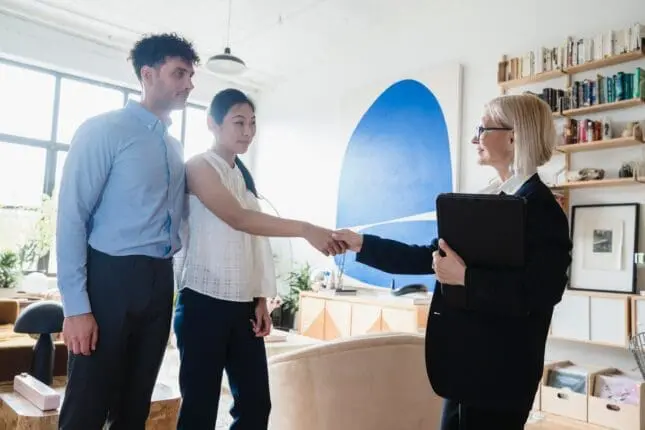 Photo of a young couple and their therapist with the young woman and the therapist shaking hands