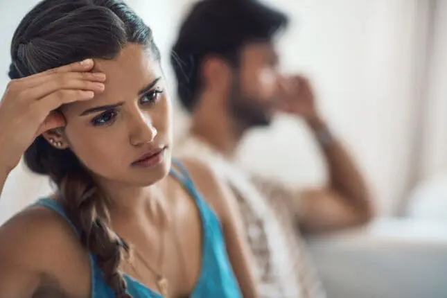 A couple in distress looks in opposite directions / Photo Credit: iStock