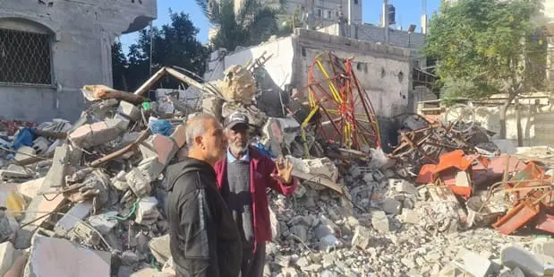 Jamil, in front, talking with a man in Rafah whose home has been crushed by Israeli bombing.