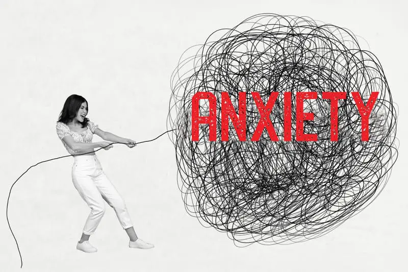 A woman pulling at one thread in a ball of anxiety