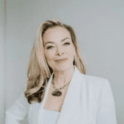 Blonde woman in white blazer smiling