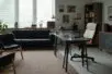 An empty therapist office with a desk, two chairs, and a couch
