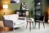 An empty therapist office with an off white couch and brown chair facing each other