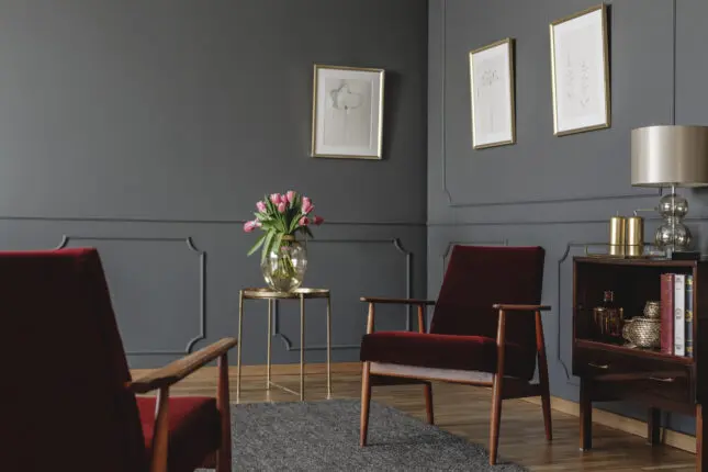 An empty therapist office with two red velvet covered chairs