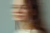 The blurred face of a woman turning to face the camera