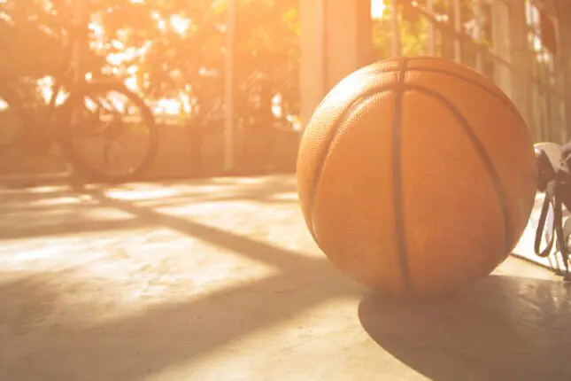An abandoned basketball resting on the floor