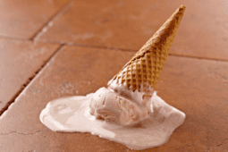 An ice cream cone accidentally dropped on the ground slowly melts