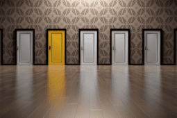 A rows of doors side by side, all in white except for one that is bright yellow