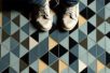 A pair of sneakers on a colorful, geometrically tiled floor