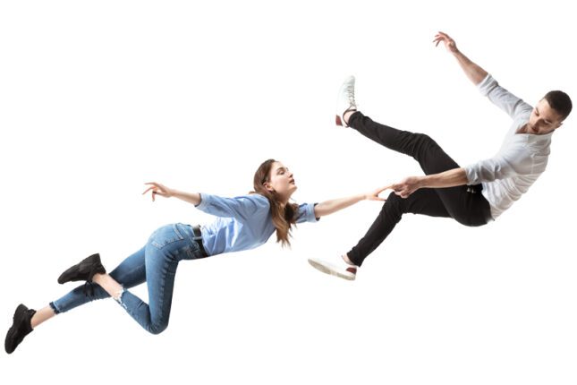 A couple floats and falls through space, reaching for each other